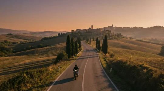 Motociclista su strada statale panoramica italiana con paesaggio rurale